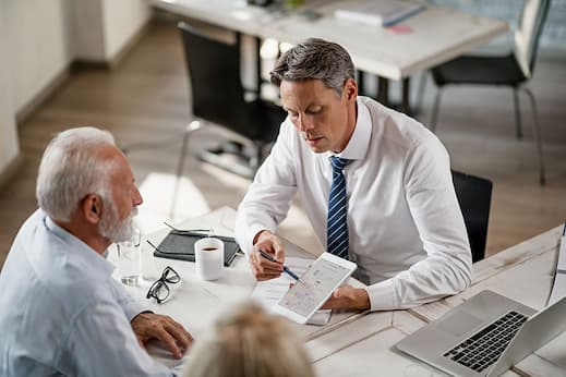 Insurance agent presenting on a mobile device to an elderly couple